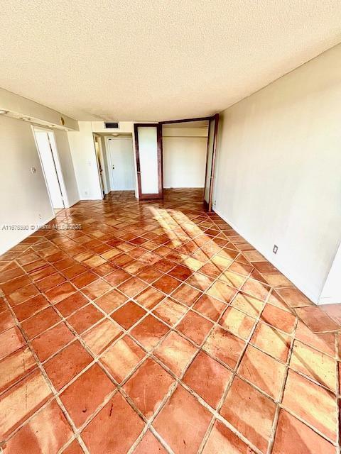 unfurnished room with a textured ceiling