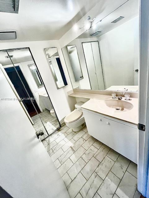 bathroom with toilet, vanity, and tile patterned flooring