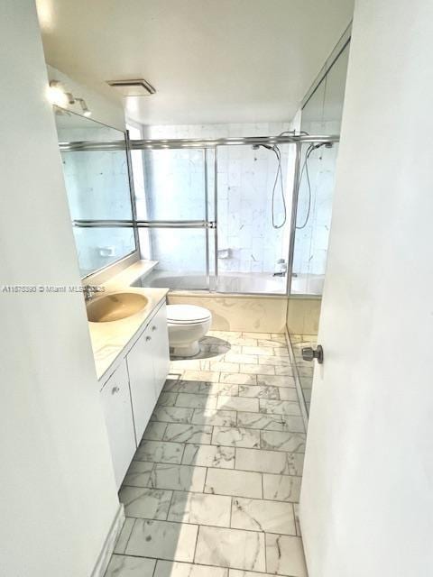 full bathroom featuring combined bath / shower with glass door, vanity, and toilet