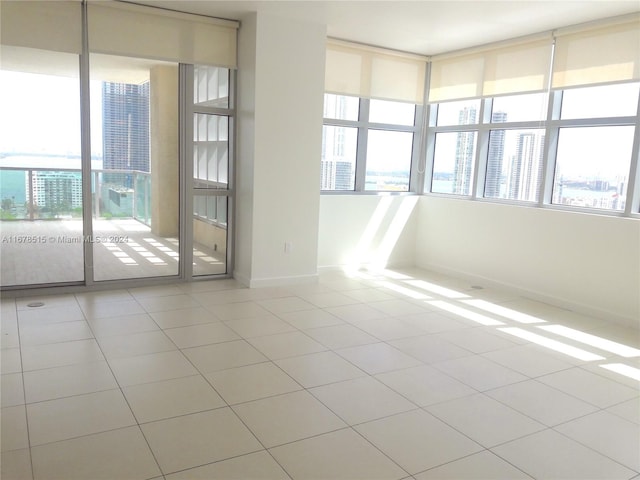 unfurnished room featuring light tile patterned flooring and plenty of natural light