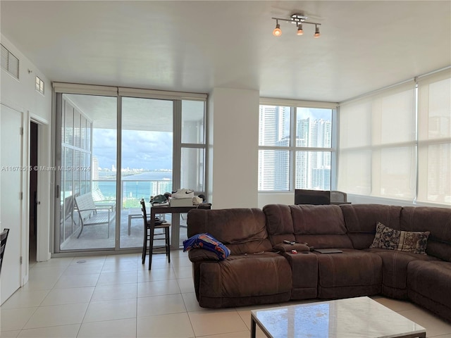 tiled living room with a water view and floor to ceiling windows