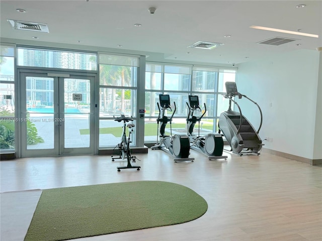 gym featuring a wall of windows and a healthy amount of sunlight