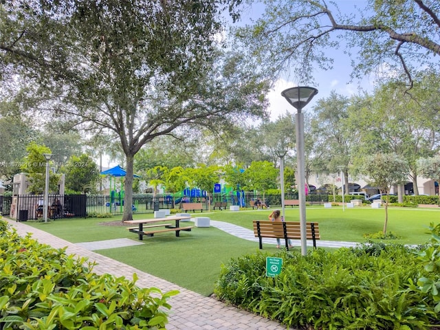 view of property's community with a playground and a yard