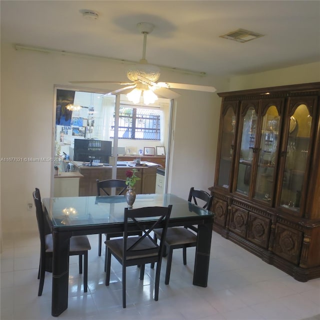 dining space with ceiling fan with notable chandelier