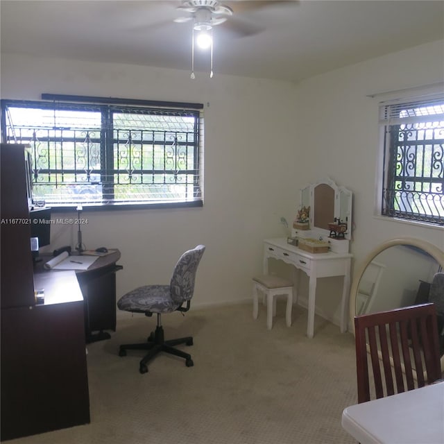 carpeted home office with a wealth of natural light and ceiling fan