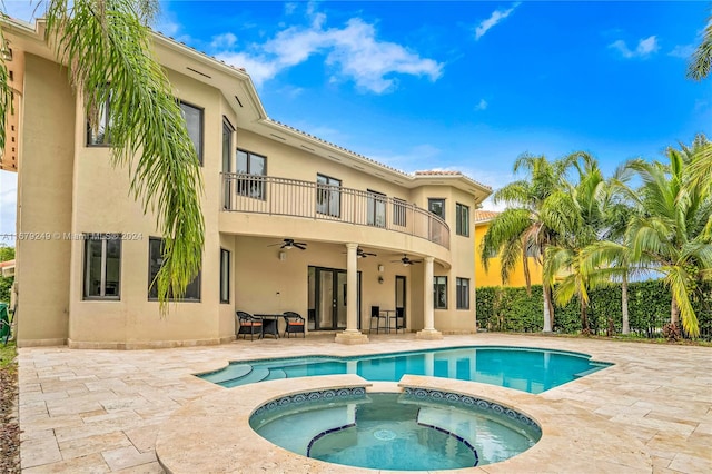 rear view of property with a patio, a balcony, a pool with hot tub, and ceiling fan