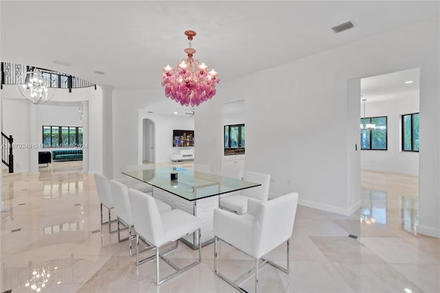 dining area featuring a chandelier and ornate columns