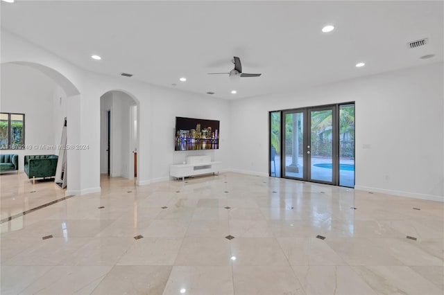 unfurnished living room featuring french doors and ceiling fan