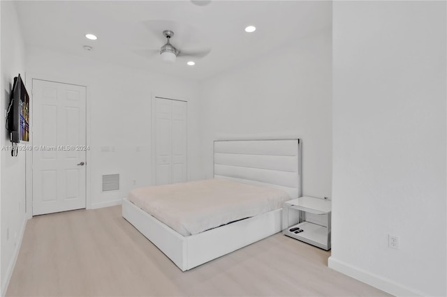 bedroom with light hardwood / wood-style flooring, a closet, and ceiling fan