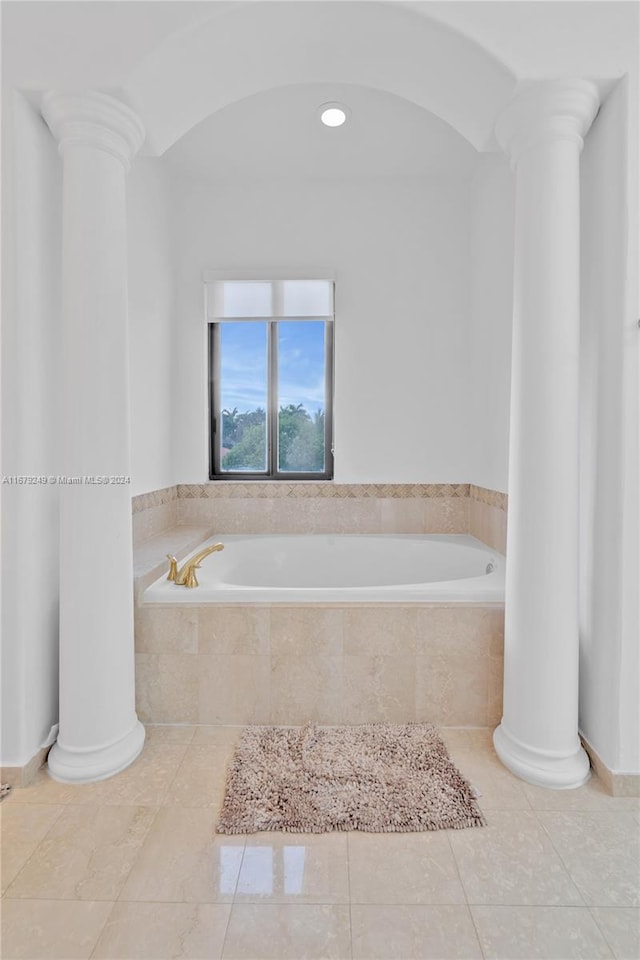 bathroom with tiled tub and tile patterned flooring