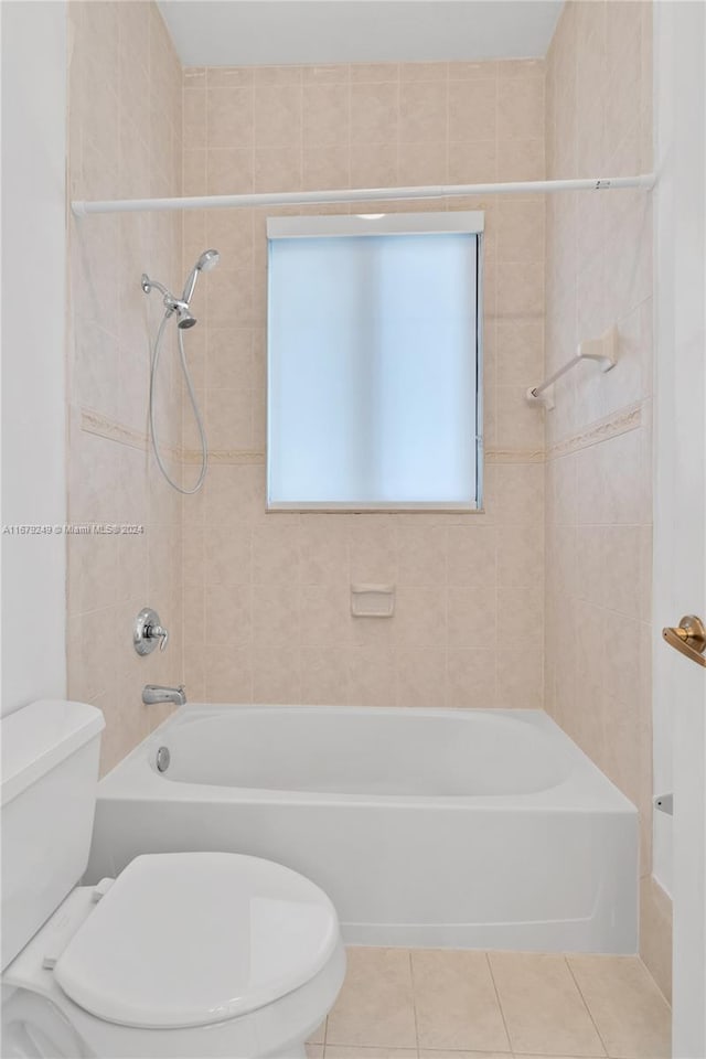 bathroom featuring toilet, tiled shower / bath combo, and tile patterned floors