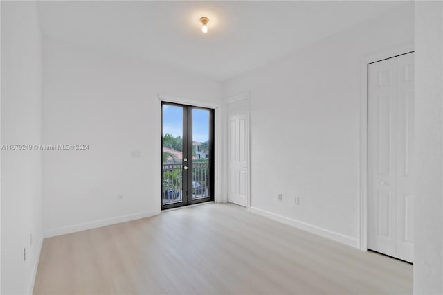 unfurnished room featuring french doors and light hardwood / wood-style flooring