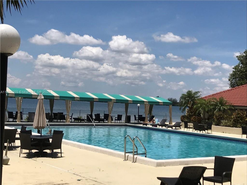 view of pool featuring a patio and a water view