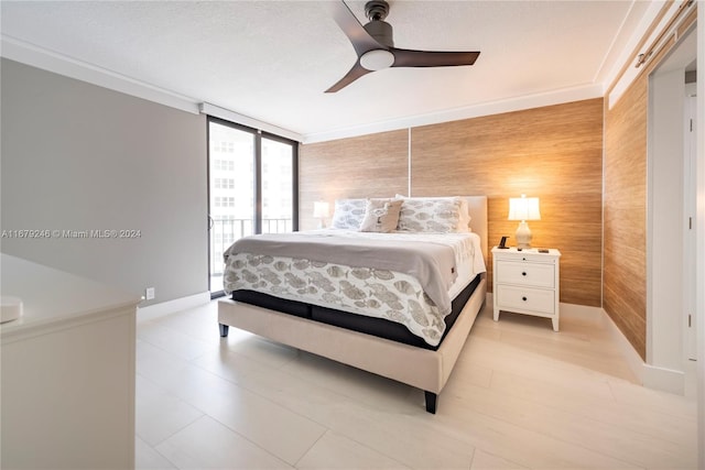 bedroom featuring wood walls, expansive windows, crown molding, and ceiling fan