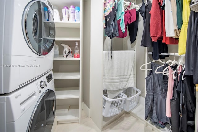 laundry area with light tile patterned flooring and stacked washer and dryer