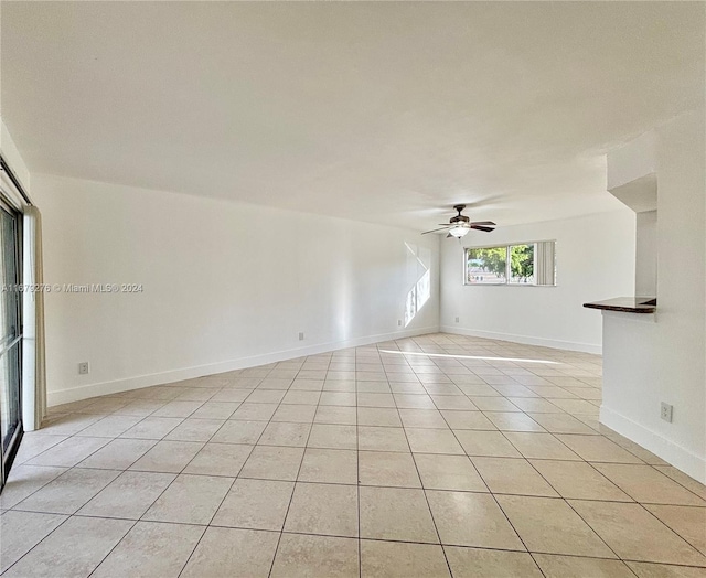 empty room featuring light tile patterned floors and ceiling fan