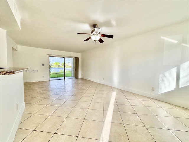 tiled empty room featuring ceiling fan