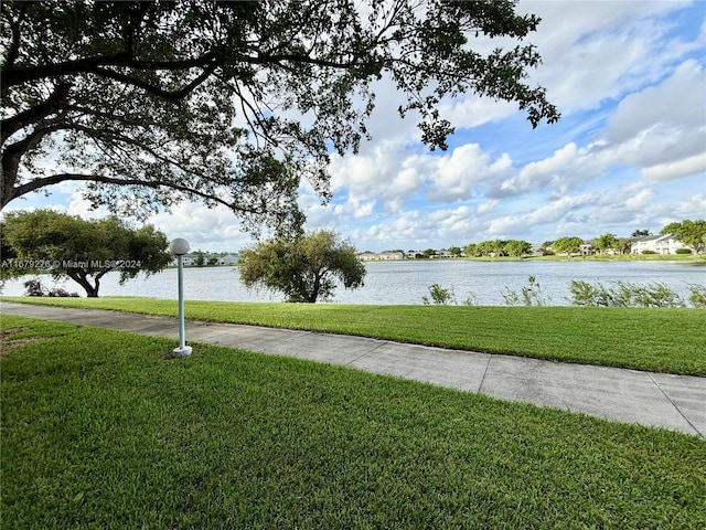 view of property's community featuring a water view and a lawn