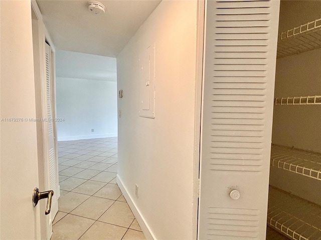 corridor featuring electric panel and light tile patterned floors