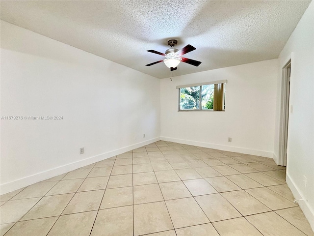 spare room with ceiling fan, a textured ceiling, and light tile patterned flooring