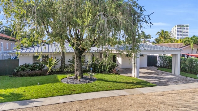 ranch-style house featuring a front lawn and a carport