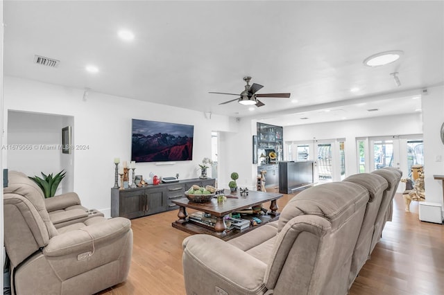 living room featuring french doors, light hardwood / wood-style flooring, and ceiling fan