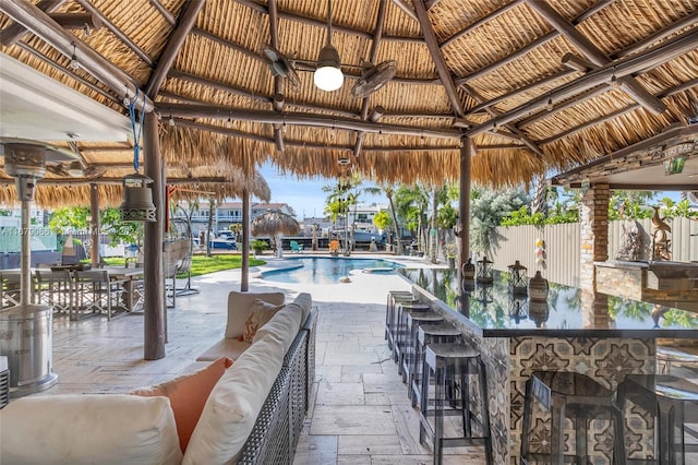 view of patio / terrace featuring an outdoor bar, a gazebo, and a fenced in pool