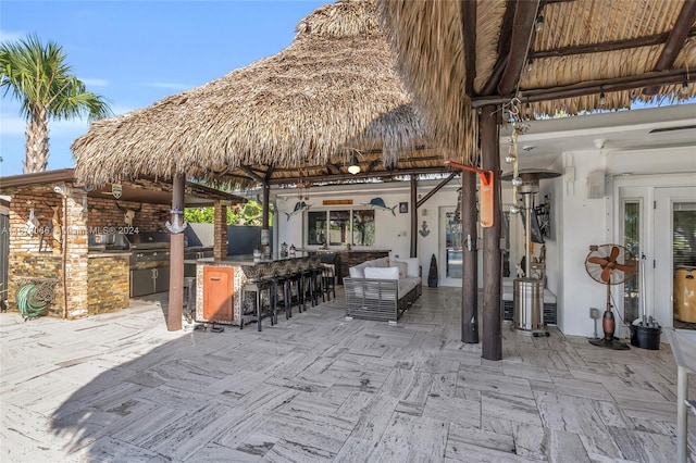 view of patio with french doors, grilling area, an outdoor kitchen, and a bar