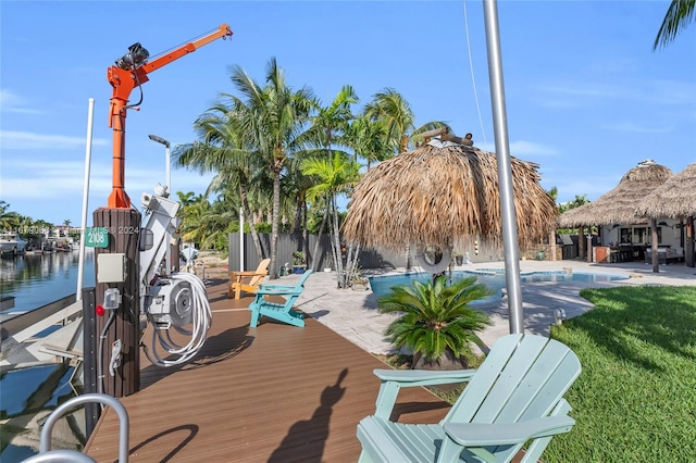 view of dock featuring a patio area, a yard, a gazebo, a fenced in pool, and a water view