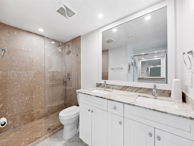 bathroom with vanity, a shower with shower door, and toilet