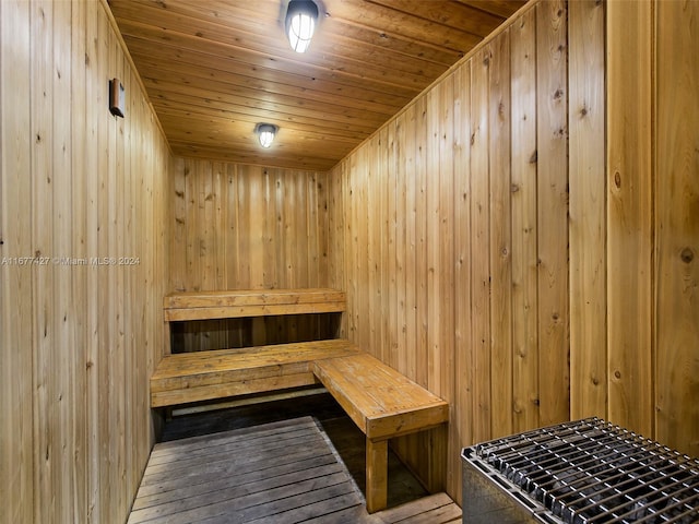 view of sauna with wooden ceiling and wooden walls