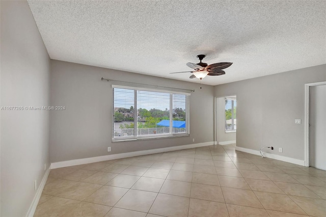 tiled spare room with a textured ceiling and ceiling fan