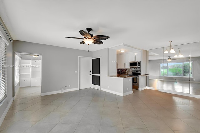 kitchen with decorative backsplash, kitchen peninsula, hanging light fixtures, white cabinetry, and appliances with stainless steel finishes