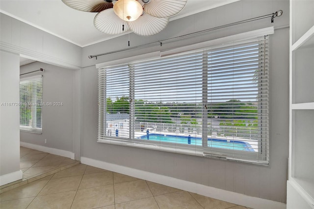 tiled spare room with ceiling fan