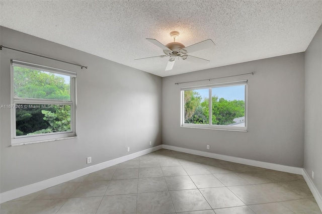 unfurnished room featuring light tile patterned floors, a textured ceiling, a healthy amount of sunlight, and ceiling fan