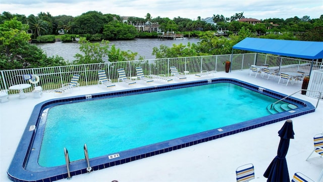 view of pool featuring a patio and a water view