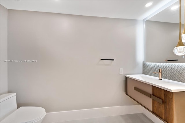 bathroom featuring backsplash, vanity, and toilet