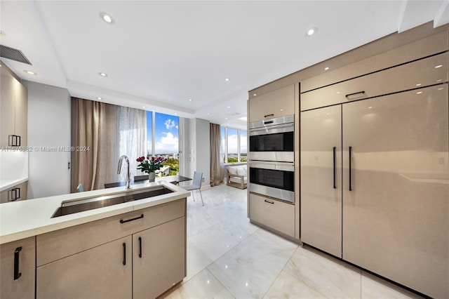 kitchen with paneled refrigerator, double oven, and sink