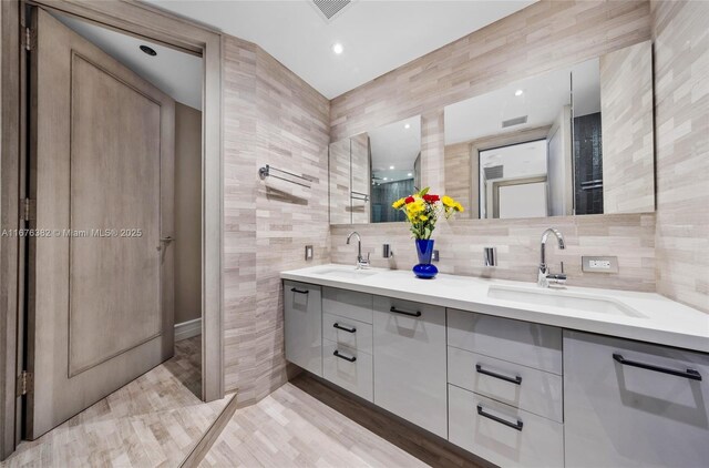 bathroom with decorative backsplash, hardwood / wood-style floors, vanity, and tile walls