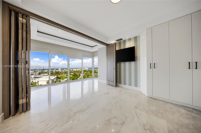 interior space featuring a raised ceiling and a wealth of natural light