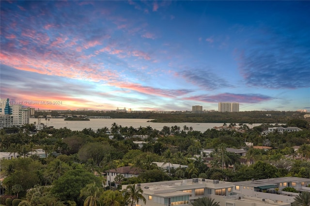 aerial view at dusk featuring a water view