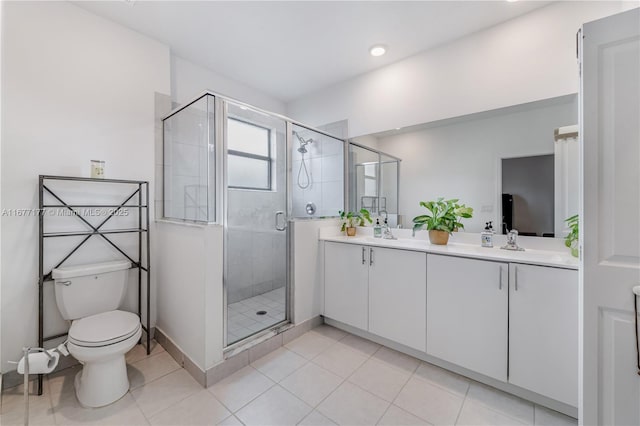 full bath featuring tile patterned floors, toilet, a stall shower, a sink, and double vanity