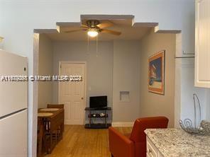 living room with ceiling fan and light wood-type flooring