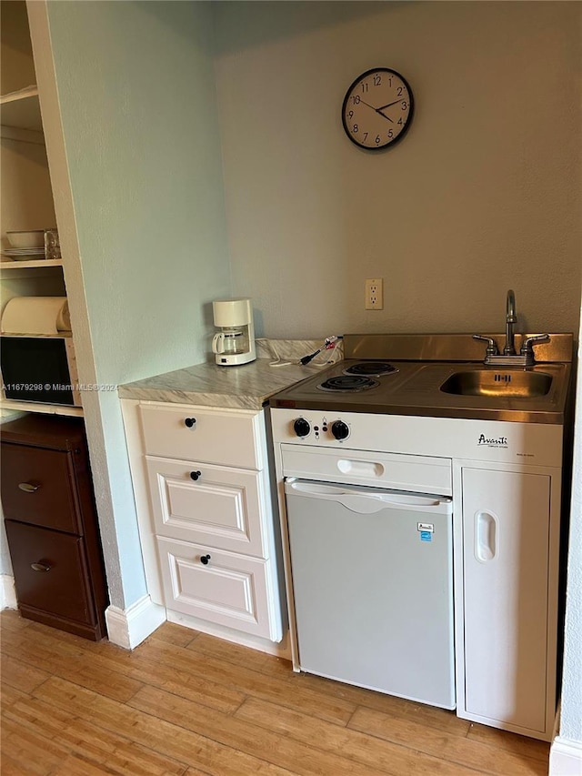 kitchen featuring sink, white cabinets, and light hardwood / wood-style floors