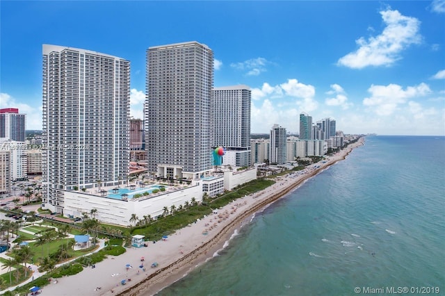 drone / aerial view featuring a water view and a view of the beach