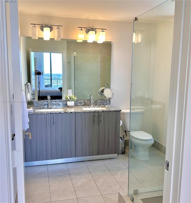 bathroom featuring vanity, toilet, tile patterned flooring, and an enclosed shower