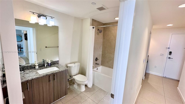 full bathroom featuring vanity, toilet, tiled shower / bath combo, and tile patterned flooring