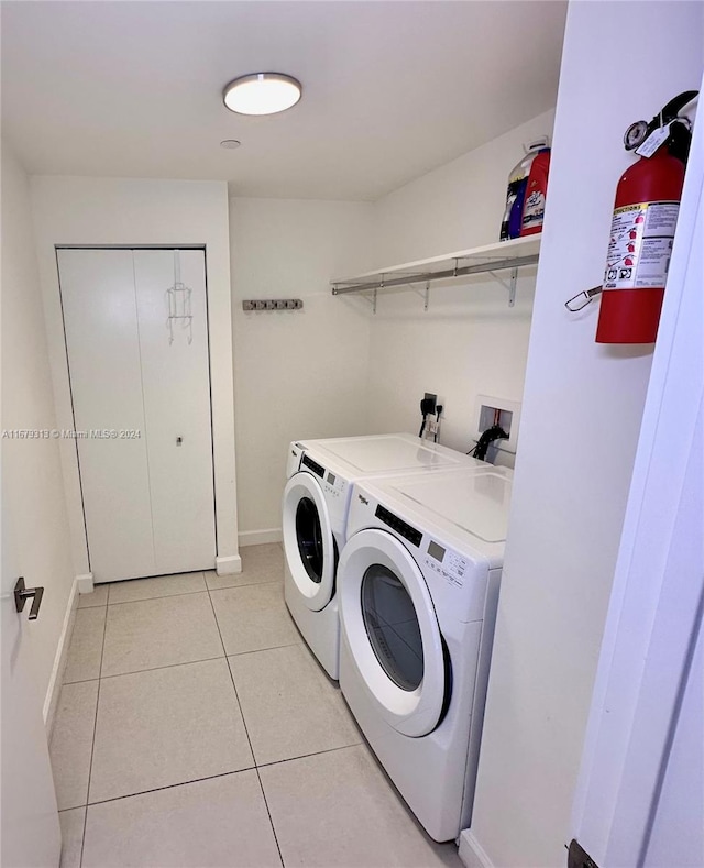 laundry room featuring washer and dryer and light tile patterned floors