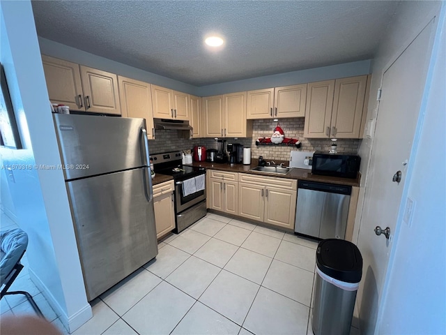 kitchen featuring light tile patterned floors, tasteful backsplash, appliances with stainless steel finishes, and sink