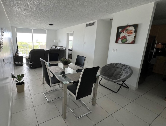 dining area with a textured ceiling and light tile patterned flooring